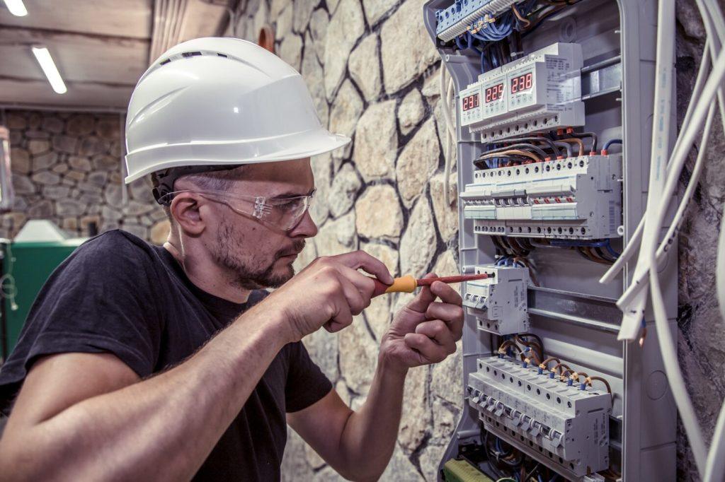 male electrician works switchboard with electrical connecting cable 169016 1473